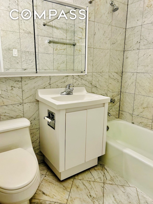 full bath with vanity, toilet, marble finish floor, tile walls, and shower / bathing tub combination