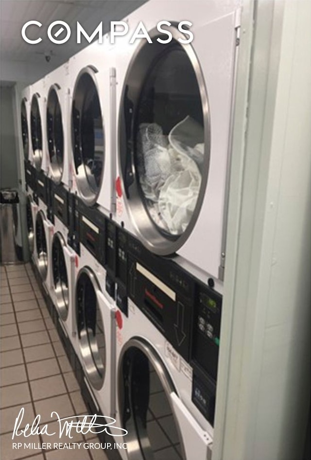 common laundry area featuring tile patterned flooring and stacked washer and dryer