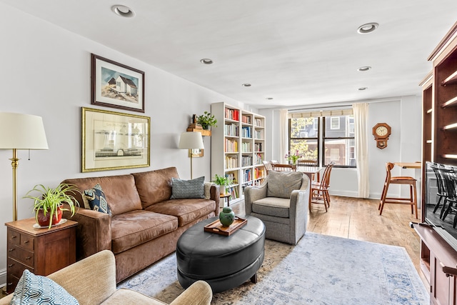 living area featuring baseboards, recessed lighting, and light wood-style flooring