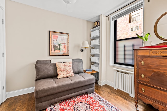 275 Webster Ave Unit 1J, New York City, NY 11230 - sitting room featuring radiator heating unit, wood finished floors, and baseboards