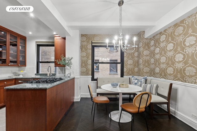 dining space with wallpapered walls, a notable chandelier, breakfast area, and a wainscoted wall