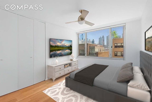 bedroom with a closet, a ceiling fan, and light wood-style flooring