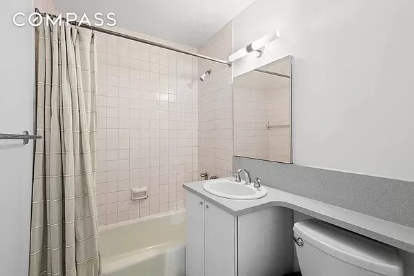 full bath featuring vanity, toilet, and shower / tub combo