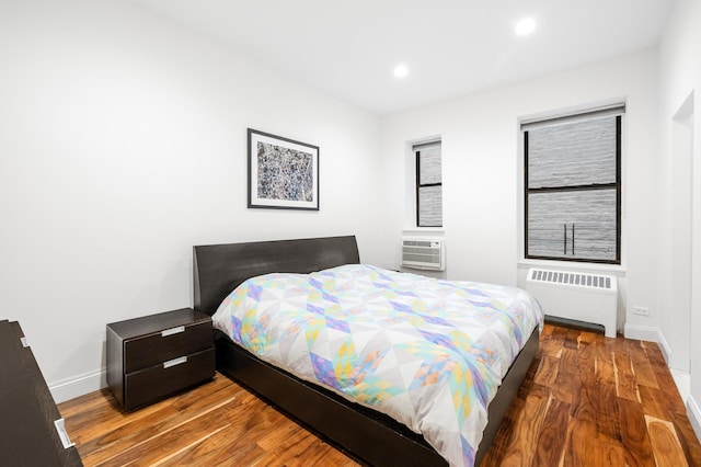 bedroom featuring radiator, baseboards, recessed lighting, and wood finished floors