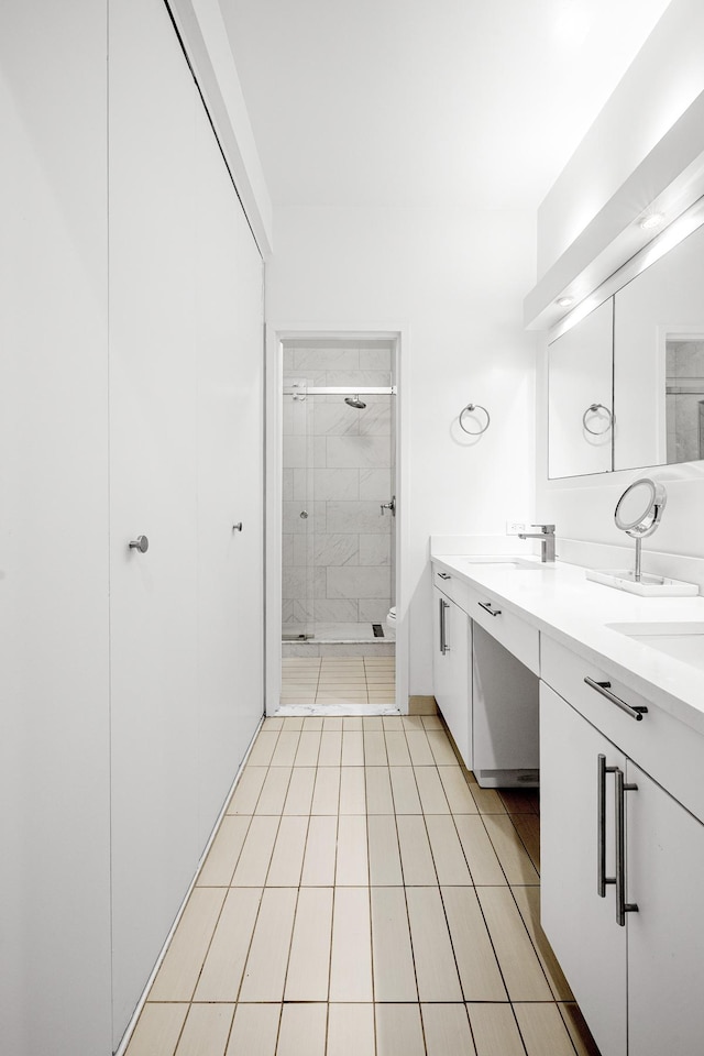bathroom with double vanity, a sink, tile patterned flooring, and a stall shower