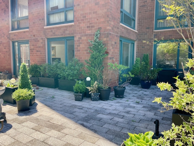 doorway to property with brick siding and a patio area