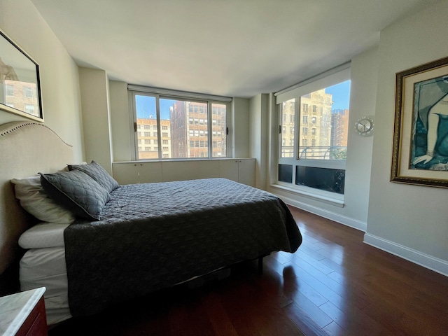 bedroom with baseboards and wood finished floors