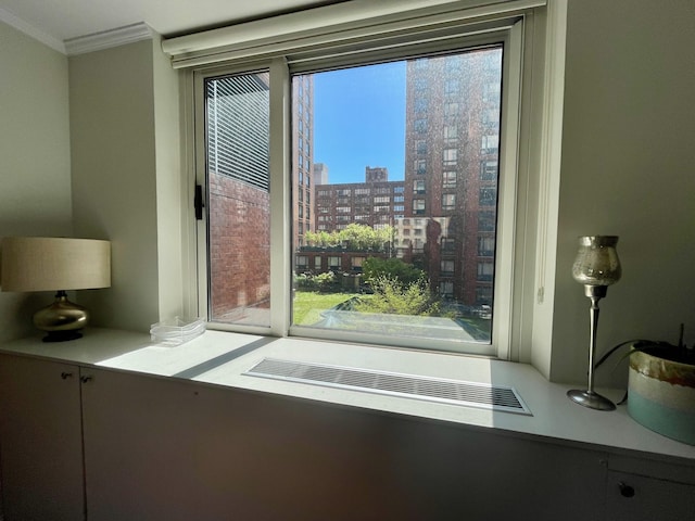 doorway to outside with crown molding, plenty of natural light, and a city view