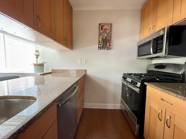 kitchen with crown molding, appliances with stainless steel finishes, baseboards, stone counters, and dark wood-style floors