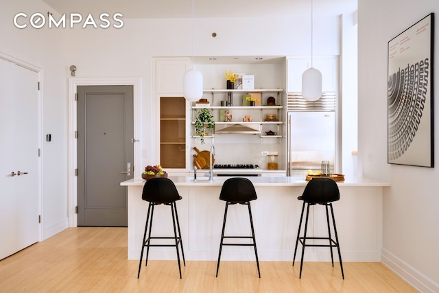 110 Livingston St Unit 6C, New York City, NY 11201 - kitchen with built in fridge, light wood-style flooring, light countertops, and a breakfast bar area