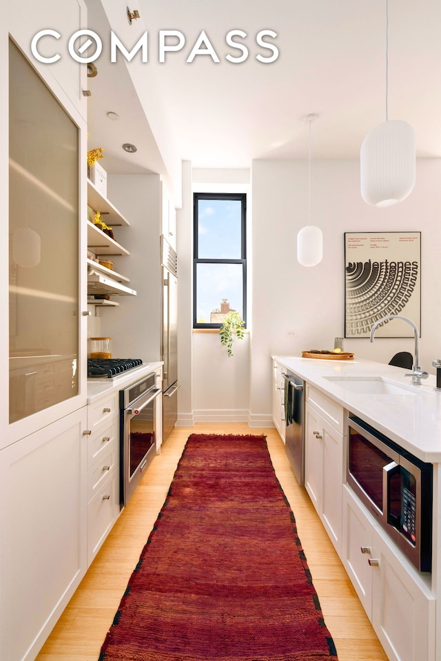 110 Livingston St Unit 6C, New York City, NY 11201 - kitchen featuring stainless steel appliances, a sink, white cabinets, and light wood-style floors