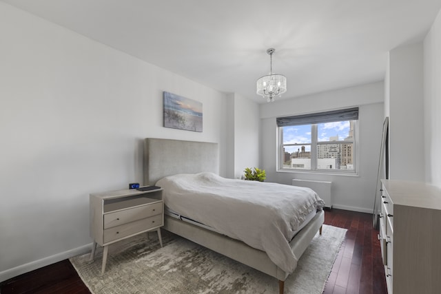 60 E 8th St Unit 11D, New York City, NY 10003 - bedroom featuring baseboards, a notable chandelier, and dark wood finished floors