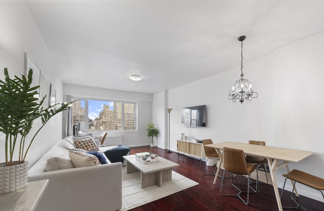 60 E 8th St Unit 11D, New York City, NY 10003 - living area with baseboards, a chandelier, and wood finished floors