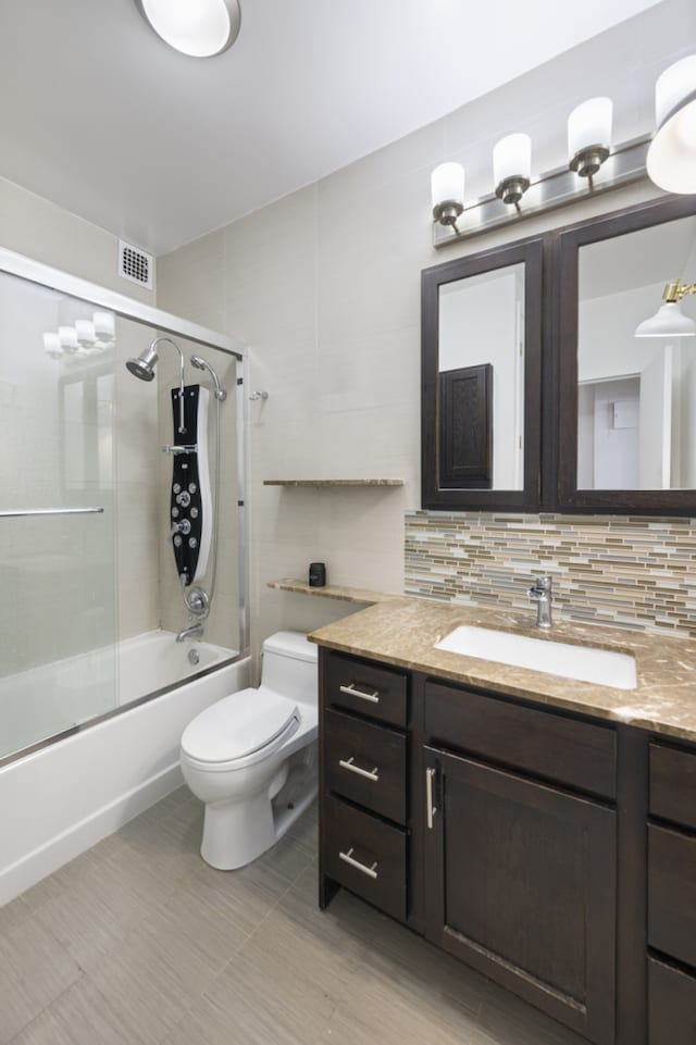 60 E 8th St Unit 11D, New York City, NY 10003 - full bathroom with vanity, toilet, combined bath / shower with glass door, backsplash, and visible vents