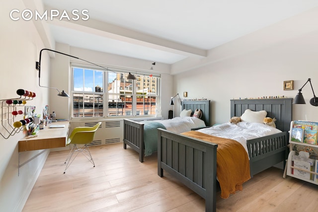 bedroom with beamed ceiling and light wood-type flooring