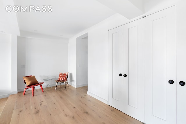 sitting room featuring baseboards and light wood finished floors