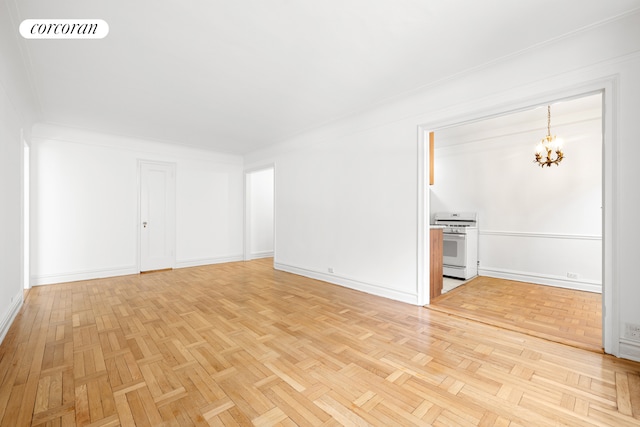 unfurnished living room with baseboards, an inviting chandelier, and visible vents