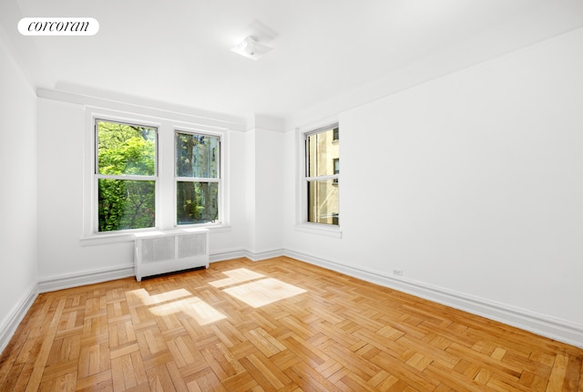 unfurnished room featuring baseboards, radiator heating unit, and visible vents
