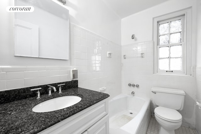 bathroom with toilet, tile walls, a healthy amount of sunlight, and vanity