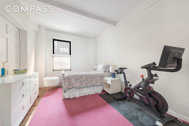 bedroom featuring baseboards, ornamental molding, beam ceiling, and wood finished floors