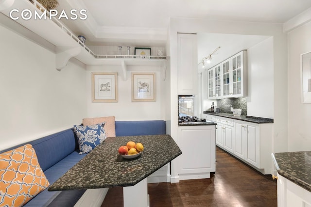 kitchen with glass insert cabinets, white cabinets, dark wood-style flooring, and breakfast area