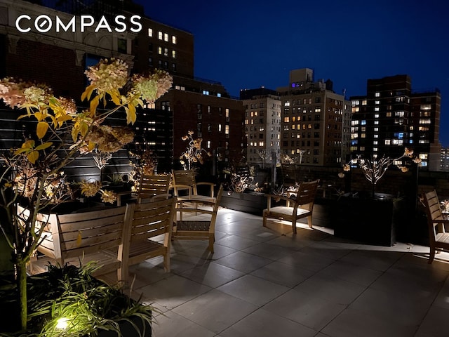 patio at night featuring a view of city lights