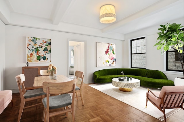 dining space featuring beamed ceiling and baseboards