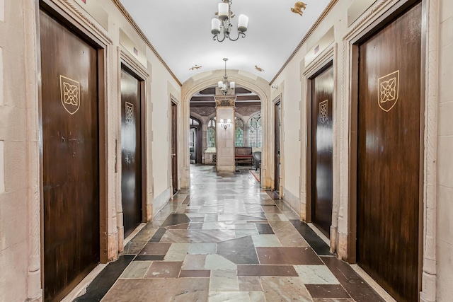 45 Tudor City Pl Unit 507, New York City, NY 10017 - hallway with a chandelier, arched walkways, lofted ceiling, stone tile flooring, and crown molding