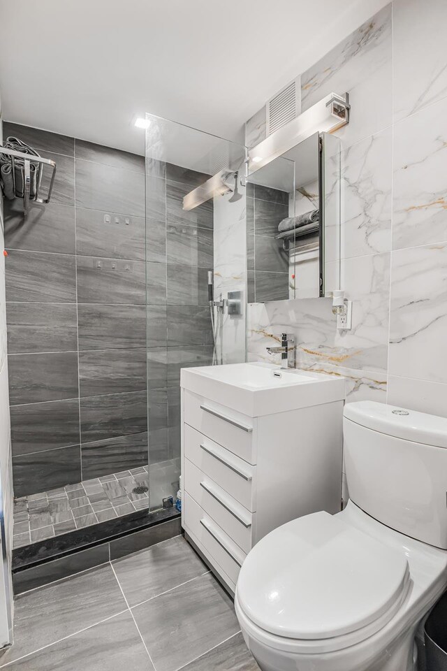 45 Tudor City Pl Unit 507, New York City, NY 10017 - full bathroom with vanity, walk in shower, tile walls, and toilet