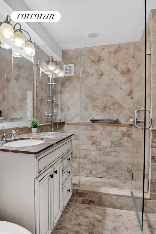 full bath featuring vanity, visible vents, and a shower stall