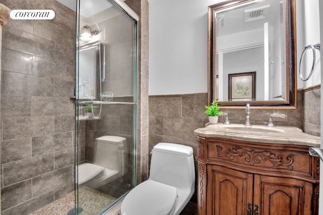 full bathroom featuring visible vents, vanity, toilet, tile walls, and a stall shower