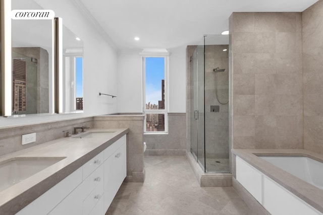 bathroom featuring tile patterned flooring, a garden tub, tile walls, a shower stall, and a sink