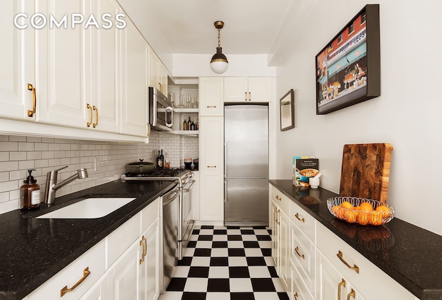 kitchen featuring open shelves, white cabinets, dark floors, a sink, and appliances with stainless steel finishes