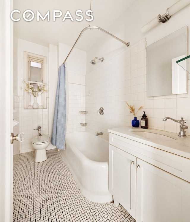 full bath featuring tile walls, shower / bath combo with shower curtain, vanity, and toilet