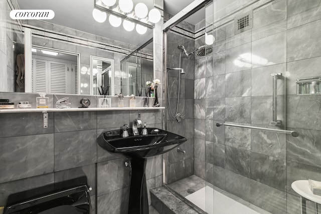 200 E 57th St Unit 14F, New York City, NY 10022 - bathroom featuring a shower stall, tile walls, and a sink