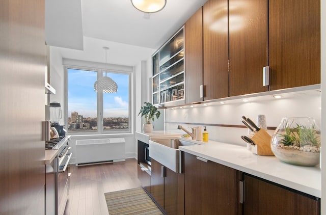 60 Riverside Blvd Unit 2801, New York City, NY 10069 - kitchen with radiator heating unit, high end stainless steel range, light countertops, a sink, and dark wood-style flooring