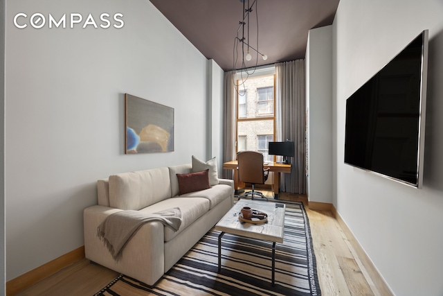 living room with baseboards and wood finished floors