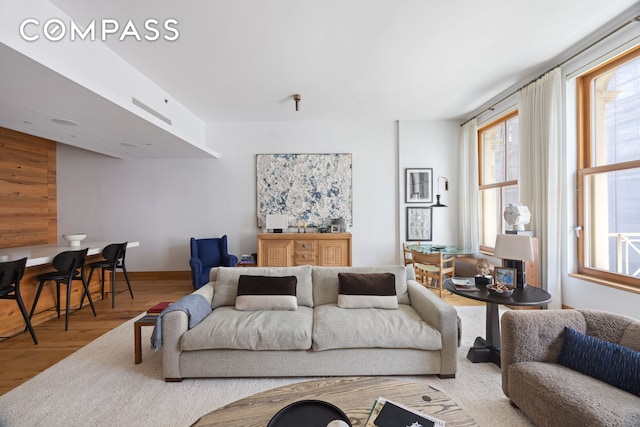 living room with baseboards, a healthy amount of sunlight, and wood finished floors
