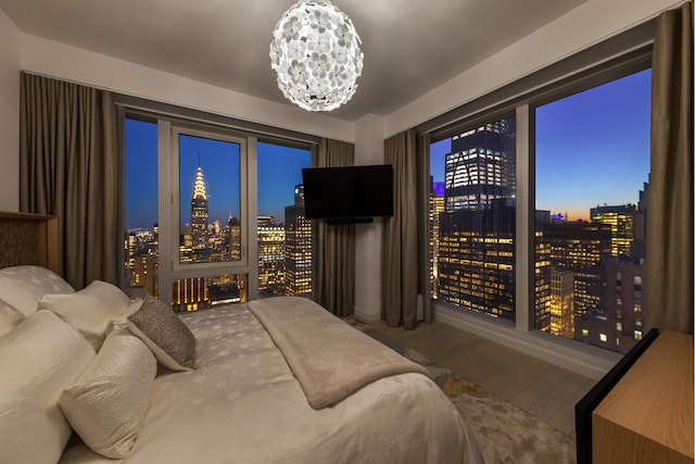 bedroom with an inviting chandelier and wood finished floors