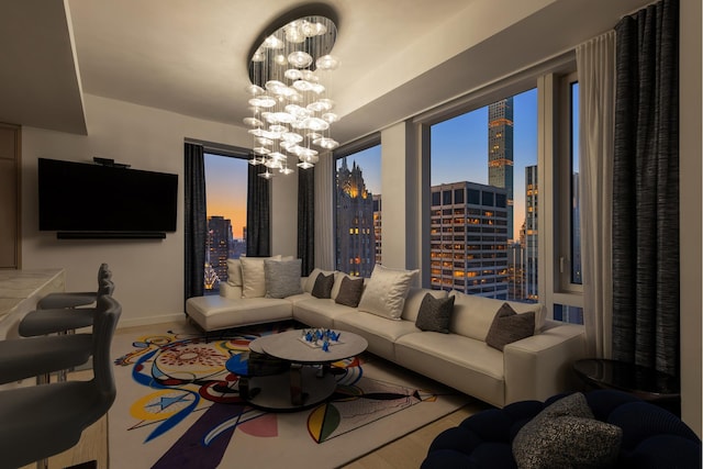 living room featuring baseboards, an inviting chandelier, and a city view