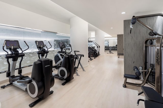 workout area with recessed lighting and light wood-style floors