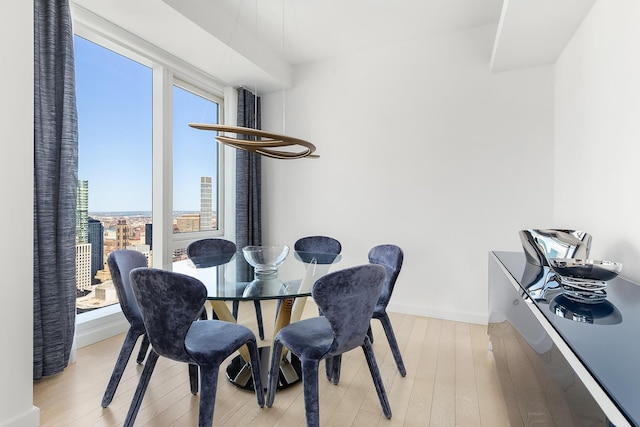 dining space featuring plenty of natural light, light wood-style floors, and baseboards
