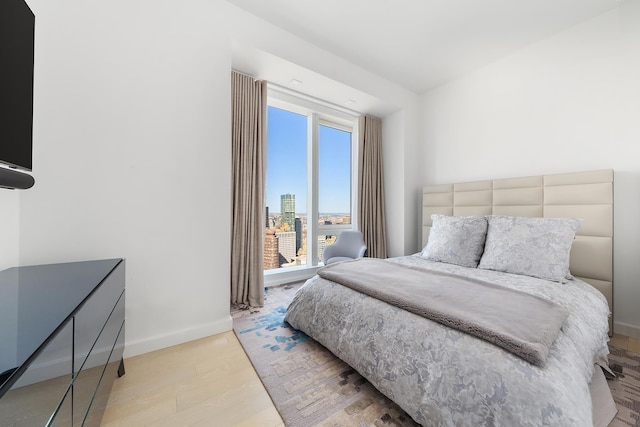 bedroom with baseboards and light wood finished floors