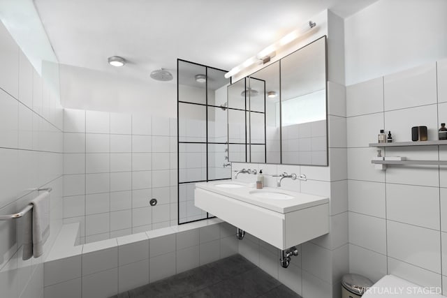 bathroom featuring toilet, tile walls, and a sink