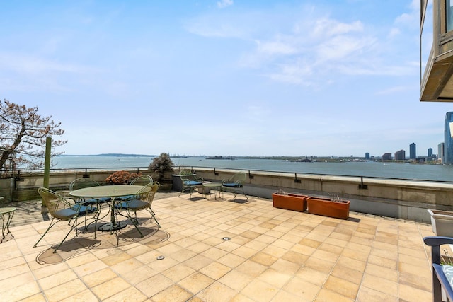 view of patio with outdoor dining area and a water view