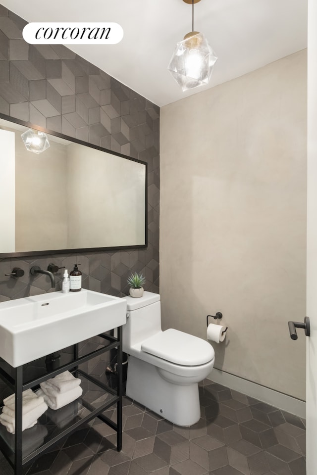 100 Barrow St Unit 5Cloft, New York City, NY 10014 - bathroom featuring toilet, tile patterned flooring, tile walls, and a sink
