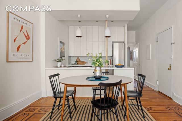 dining area with baseboards and wood finished floors