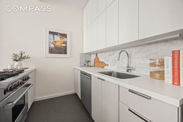 kitchen with a sink, light countertops, decorative backsplash, and stainless steel appliances