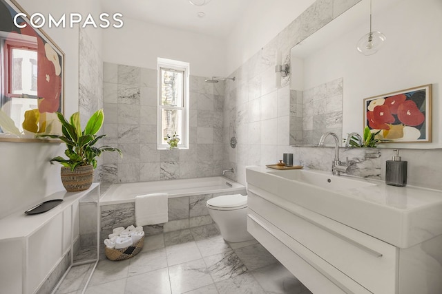 bathroom featuring toilet, tiled shower / bath, and vanity