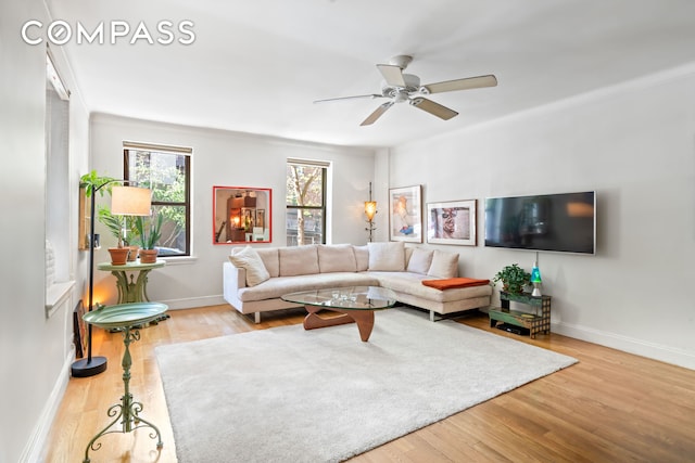 living room with a ceiling fan, baseboards, plenty of natural light, and wood finished floors